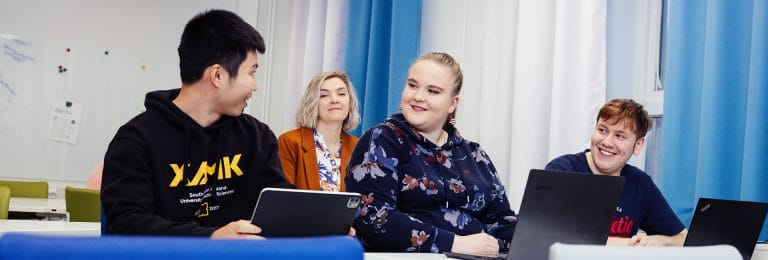 Opiskelijoita keskustelemassa luokassa.